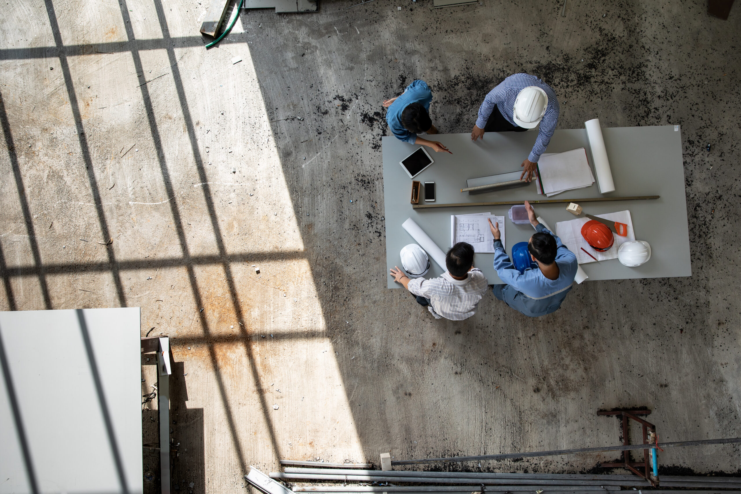 Four persons team of engineers talk together to review constucti
